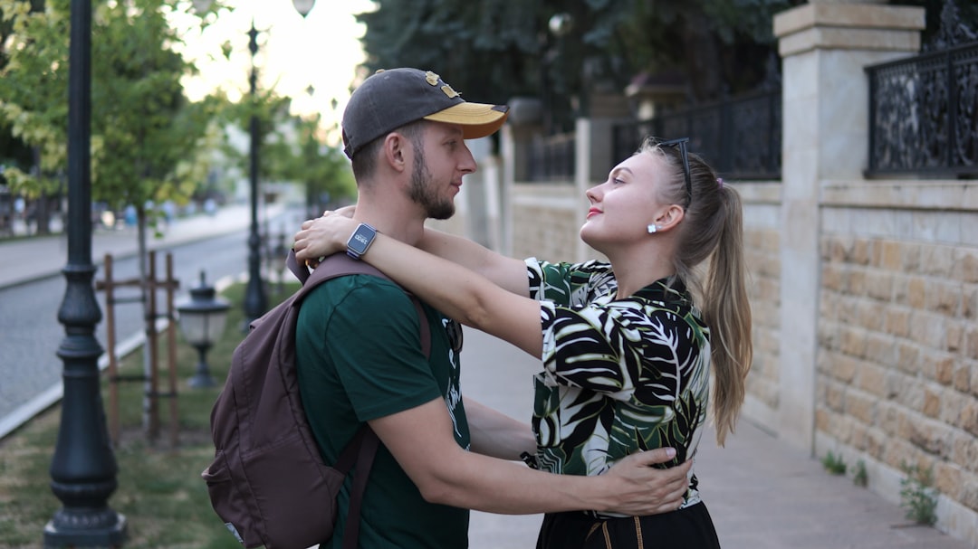 A man standing next to a woman on a sidewalk