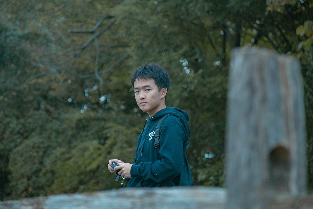 man holds camera near bridge